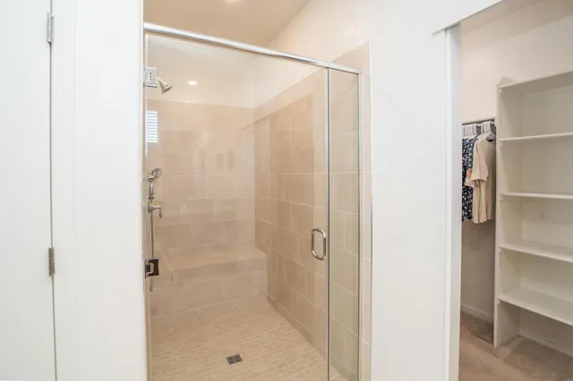 a view of walk in closet with clothes and shoes