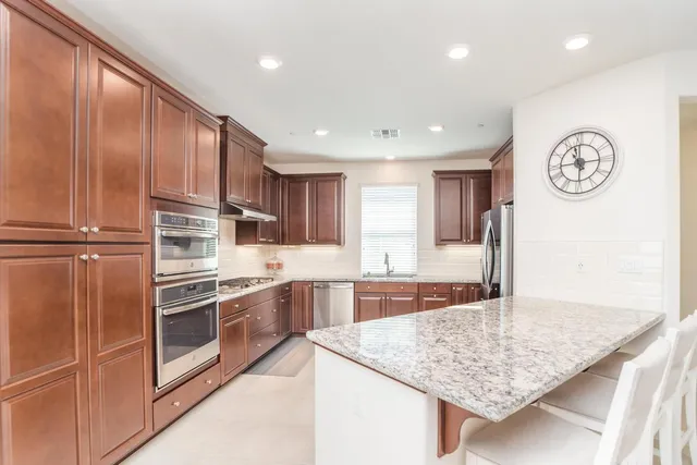 a kitchen with granite countertop cabinets stainless steel appliances and a counter space