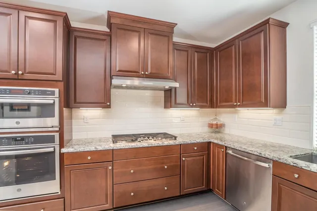a kitchen with stainless steel appliances granite countertop a refrigerator and a sink