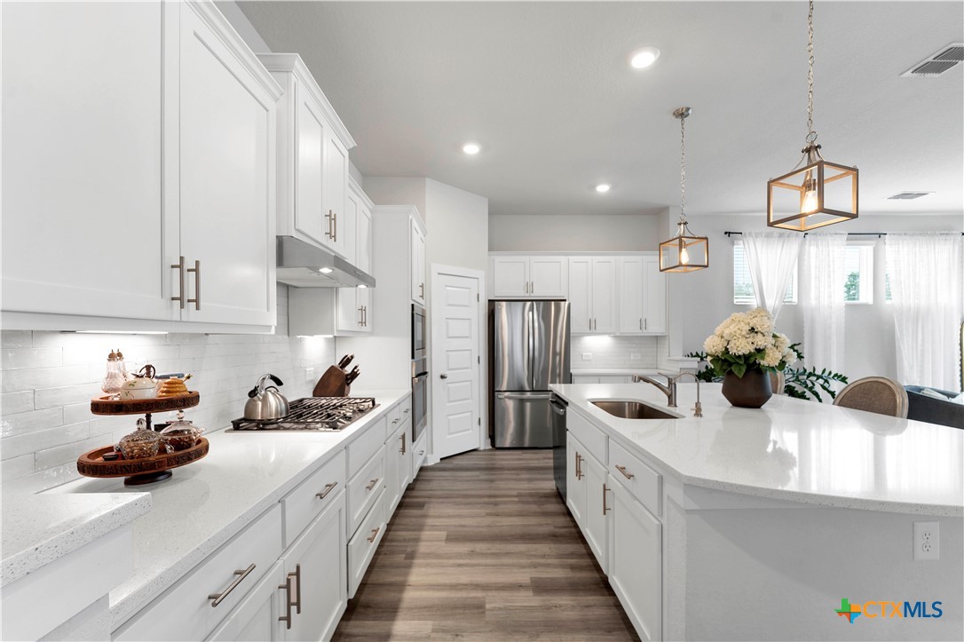 a kitchen with stainless steel appliances a sink stove and cabinets