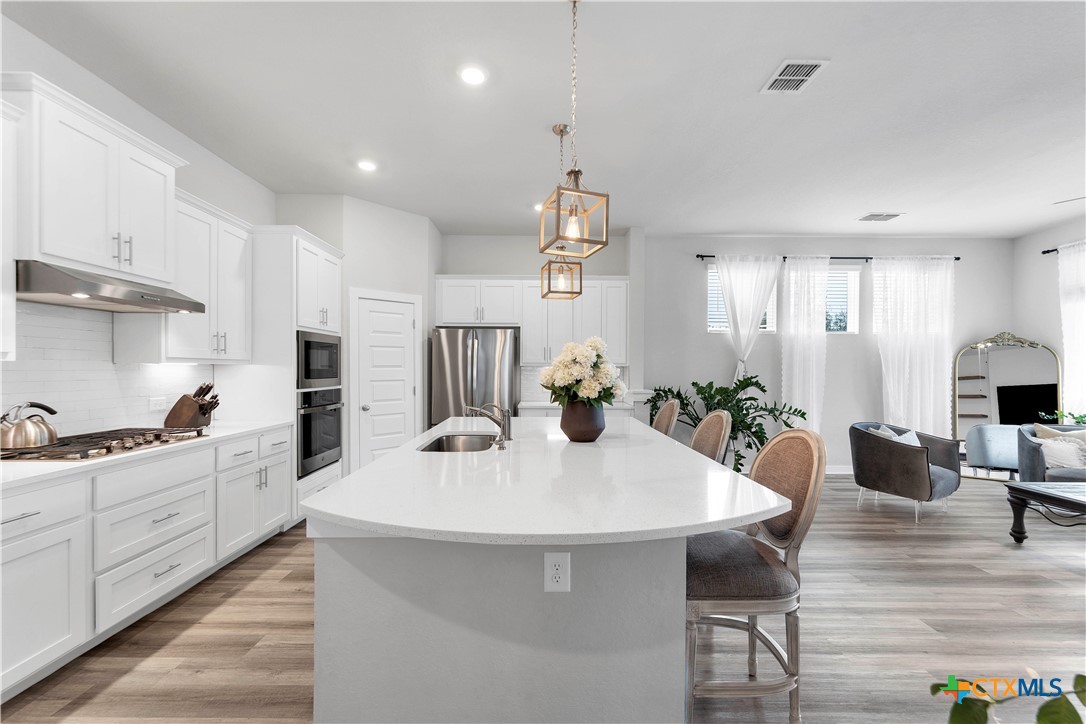 1616 Craftsman Road New Braunfels, TX 78132 - Photo 13 of 29 a kitchen with counter space dining table and stainless steel appliances