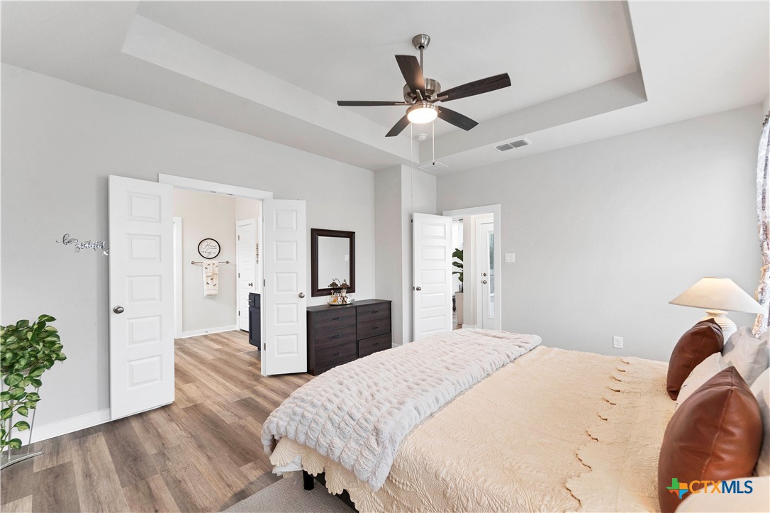 1616 Craftsman Road New Braunfels, TX 78132 - Photo 19 of 29 a bedroom with a bed and a chandelier