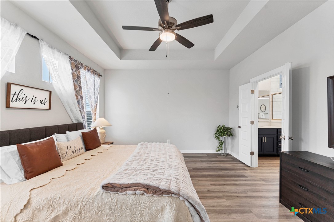 1616 Craftsman Road New Braunfels, TX 78132 - Photo 20 of 29 a bedroom with a large bed and a chandelier