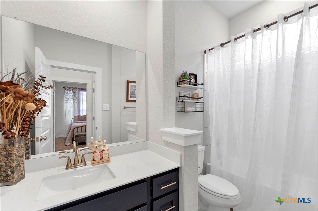 1616 Craftsman Road New Braunfels, TX 78132 - Photo 6 of 29 a bathroom with a sink a toilet and shower curtain