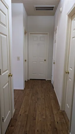 a view of a room with wooden floor and a bathroom