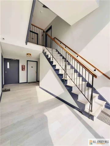 a view of staircase with railing and white walls