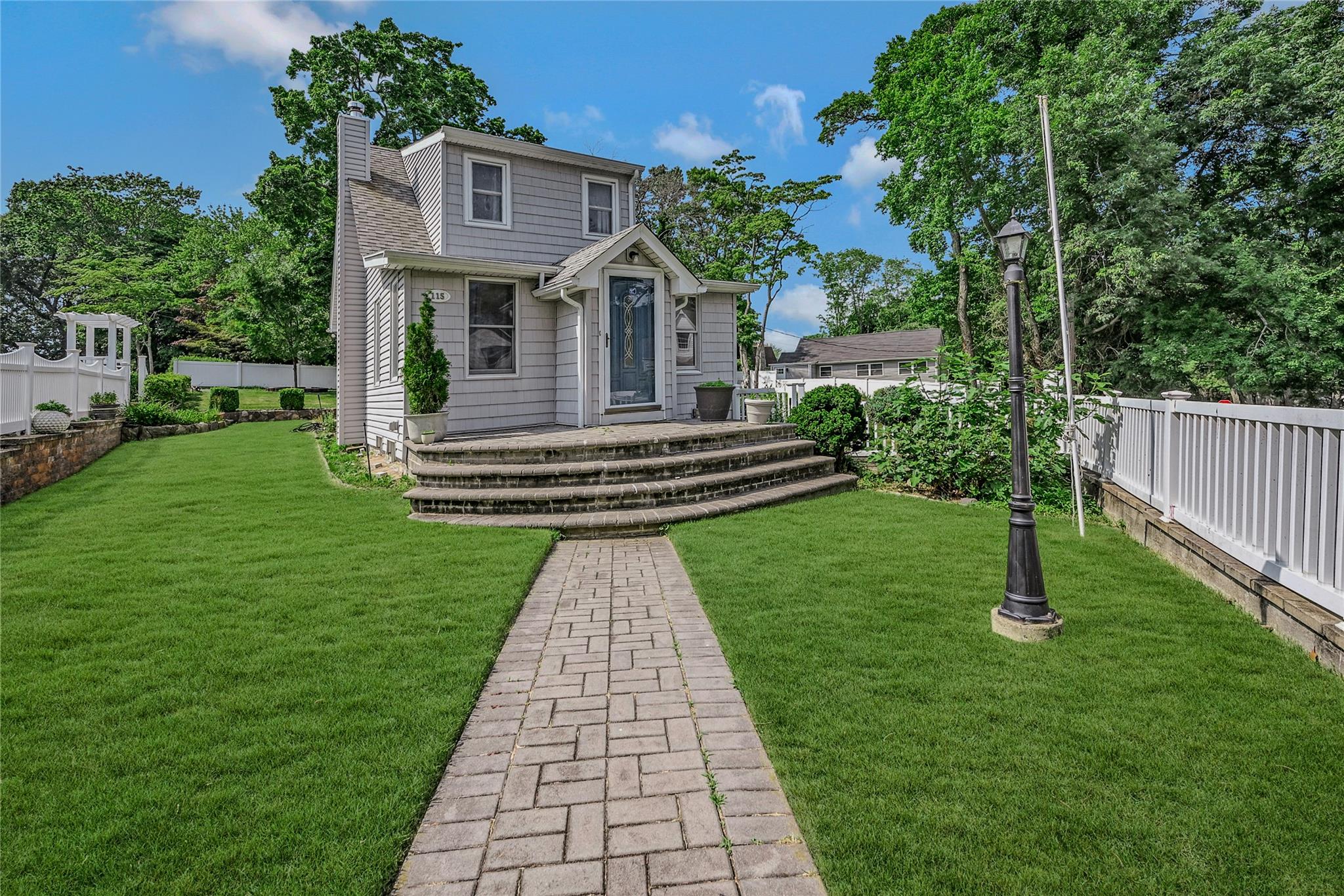 View of front facade with a fenced backyard and a chimney