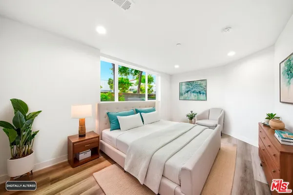 a bedroom with bed and a potted plant