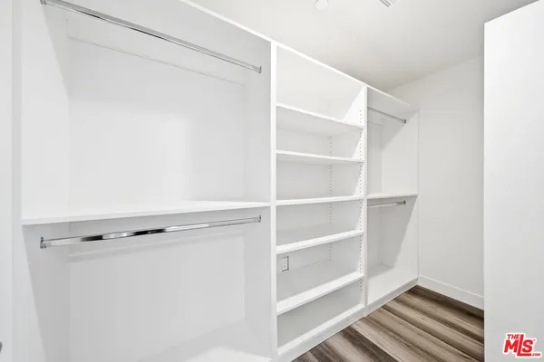 a view of walk in closet with empty racks