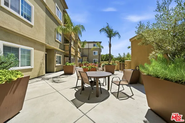 a view of a patio with couches table and chairs and potted plants