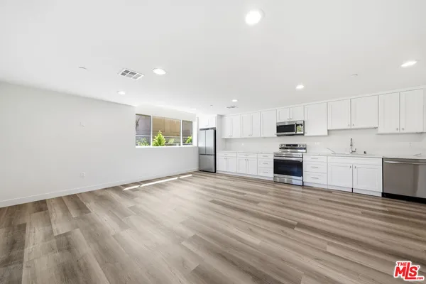 a view of kitchen with granite countertop cabinets and stove top oven