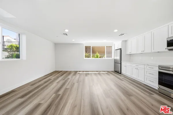 a view of an empty room with a window and fire place