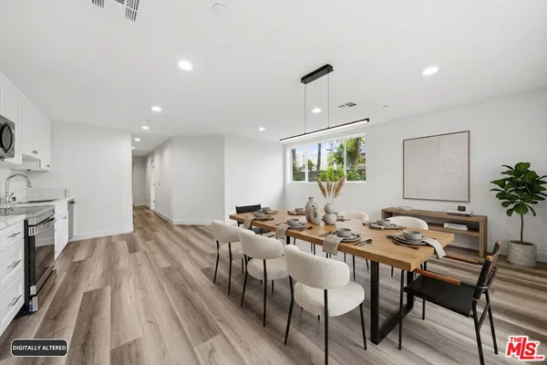 a view of a a dining room with furniture window and wooden floor