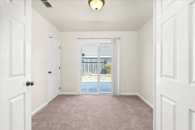 an empty room with closet and mirror