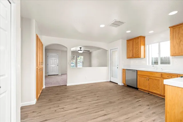 a large kitchen with a wooden floor and a window