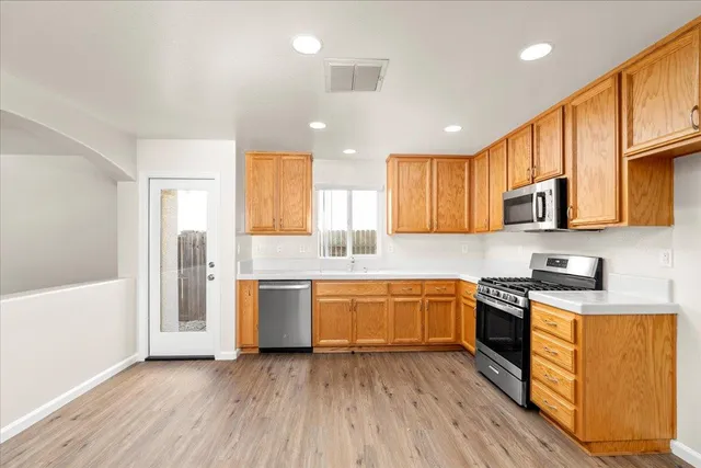 a large kitchen with stainless steel appliances granite countertop a stove a sink and a refrigerator