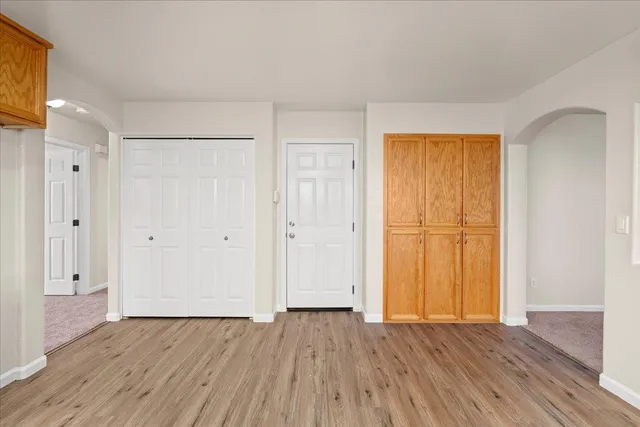 a view of empty room with wooden floor and entryway