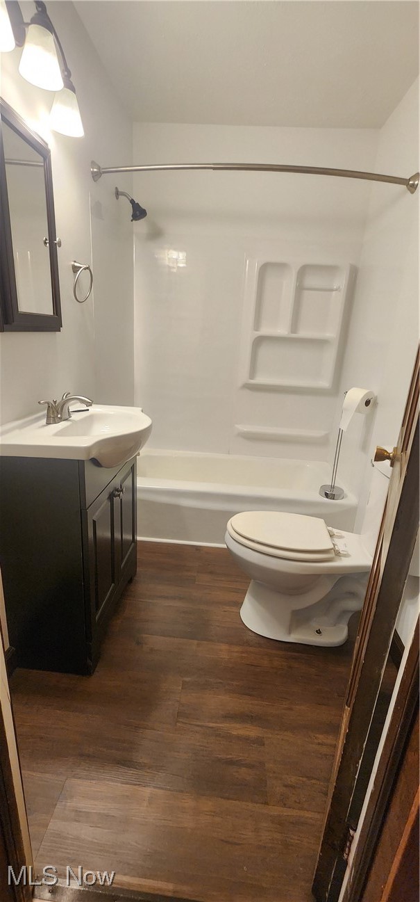 9090 Radcliffe Road Adamsville, OH 43802 - Photo 11 of 19 Full bathroom with wood-type flooring, vanity, toilet, and bathtub / shower combination