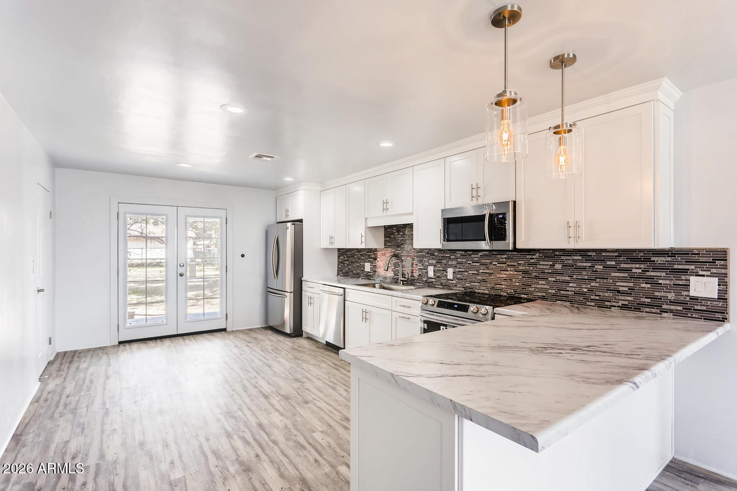 1215 South Judd Street Tempe, AZ 85281 - Photo 4 of 18 a kitchen with stainless steel appliances granite countertop a stove top oven a sink dishwasher and a refrigerator with wooden floor