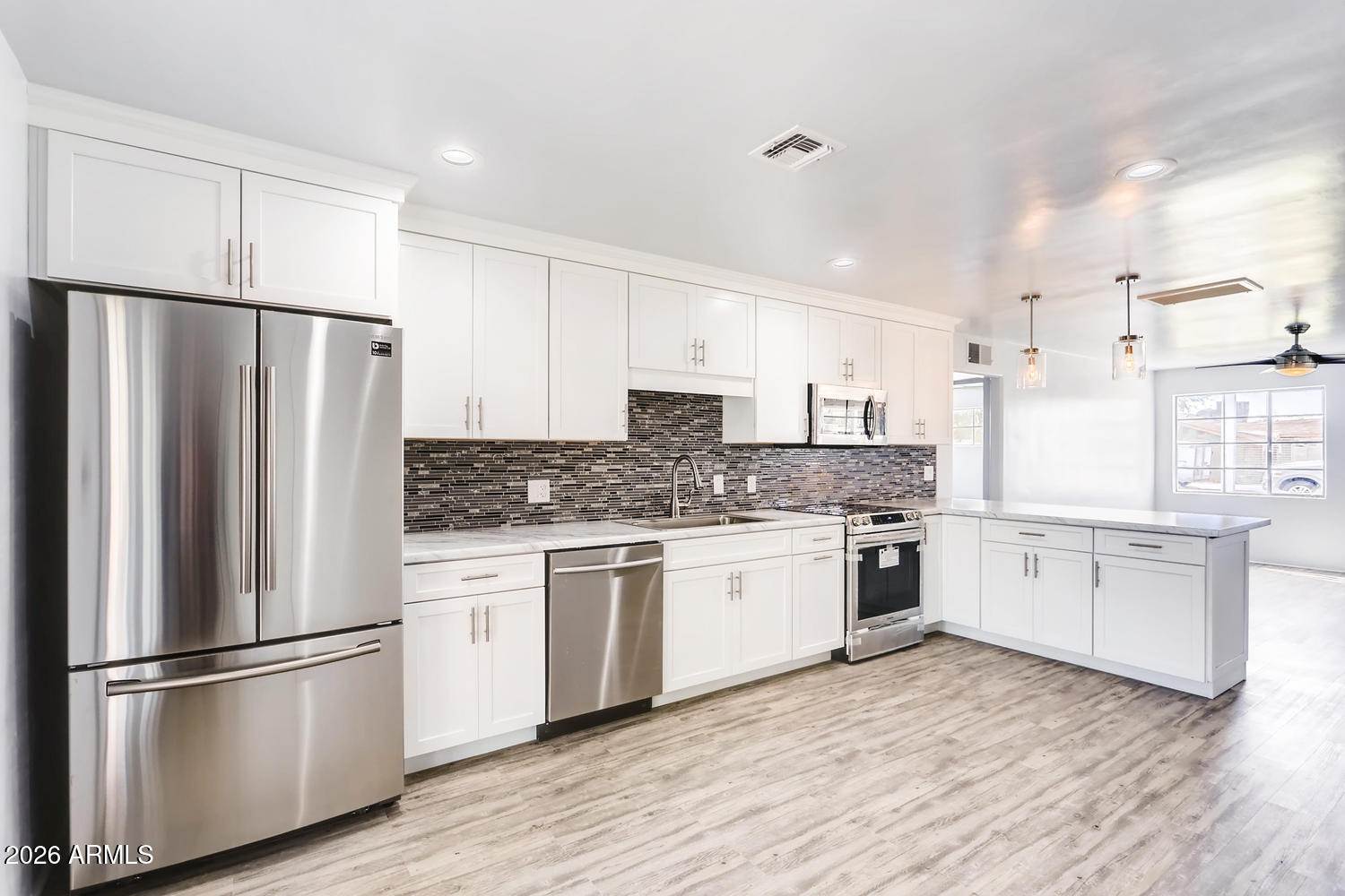 1215 South Judd Street Tempe, AZ 85281 - Photo 7 of 18 a kitchen with granite countertop stainless steel appliances a refrigerator sink and white cabinets