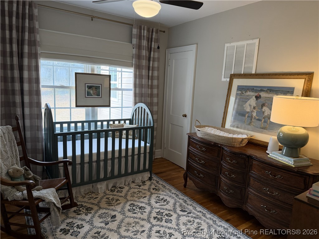 211 North Dickson Street Raeford, NC 28376 - Photo 10 of 14 a bedroom with a bed and wooden floor