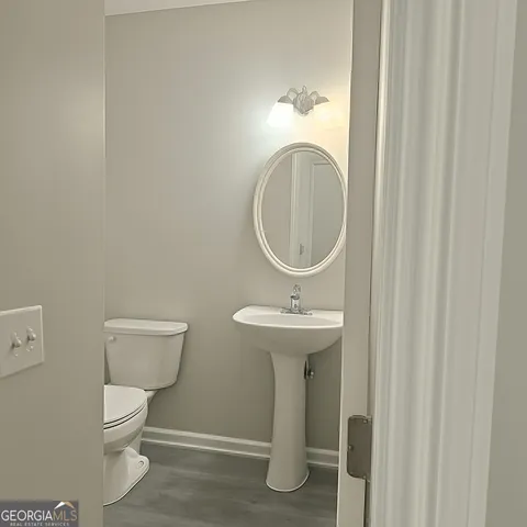 a bathroom with a toilet a sink and a mirror