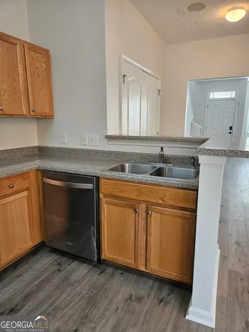 a kitchen with granite countertop wood cabinets and white appliances