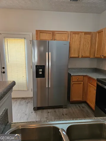 a kitchen with stainless steel appliances granite countertop a refrigerator and a stove