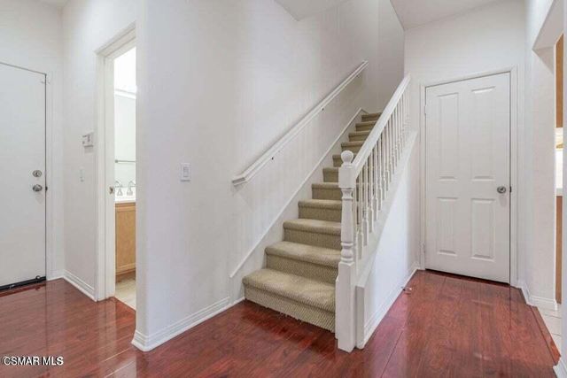 an empty room with wooden floor fireplace and windows
