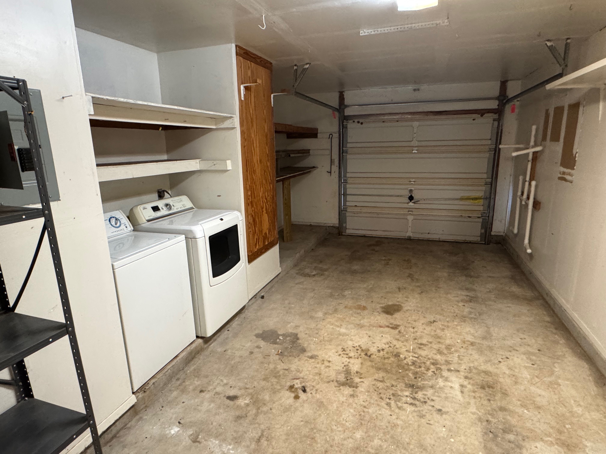3601 Leafield Drive, Unit B Austin, TX 78749 - Photo 16 of 19 Single-car garage with concrete flooring, overhead fluorescent lighting, and a built-in laundry area featuring a washer and dryer