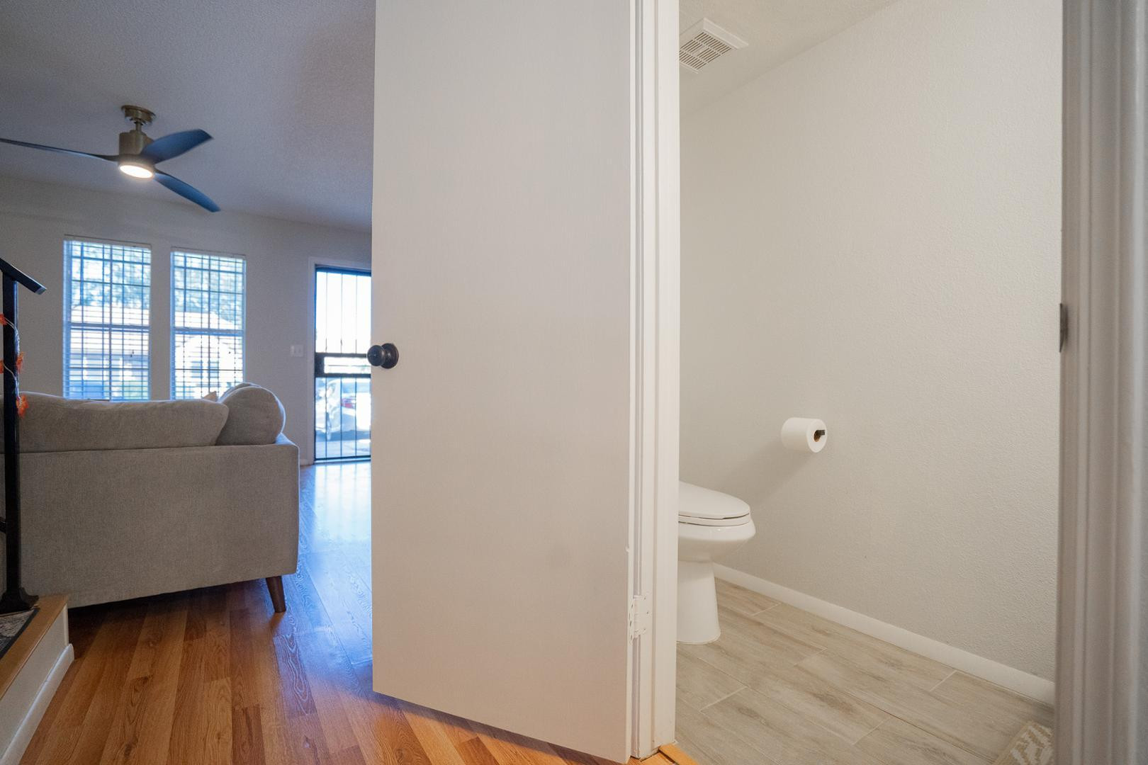 8111 West Wacker Road, Unit 70 Peoria, AZ 85381 - Photo 13 of 38 a living room with a wooden floor and a toilet