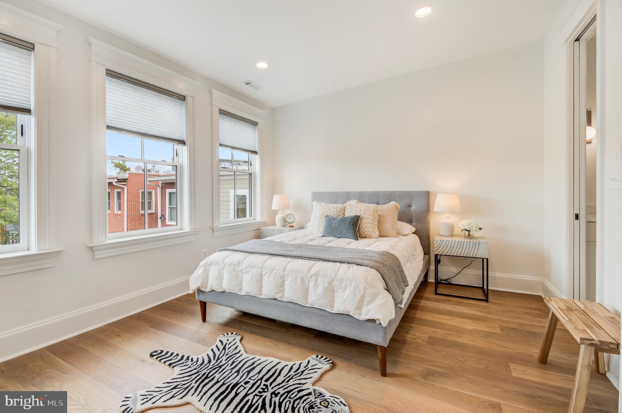 326 D Street Northeast Washington, DC 20002 - Photo 21 of 53 a bedroom with a bed lamp and a large window with wooden floor