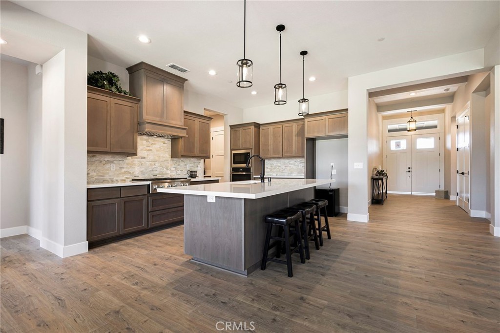 3 Haystack Court Chico, CA 95973 - Photo 19 of 75 a large kitchen with stainless steel appliances kitchen island granite countertop a stove a sink a refrigerator and a wooden cabinets