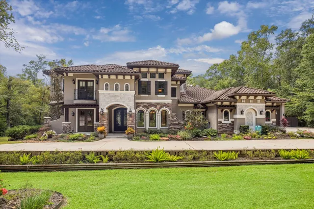 a front view of a house with a garden and lake view