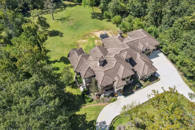 an aerial view of a house with a yard and lake view