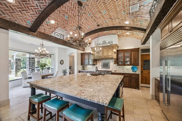 a kitchen with stainless steel appliances granite countertop a stove a sink and a refrigerator