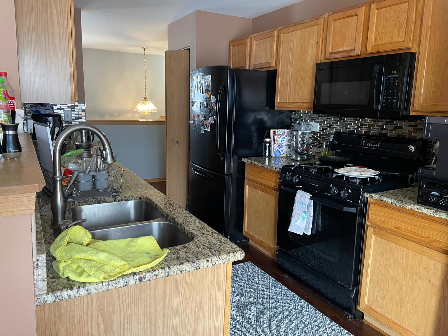 2497 Reflections Drive Aurora, IL 60502 - Photo 6 of 22 a kitchen with granite countertop a sink stainless steel appliances and cabinets