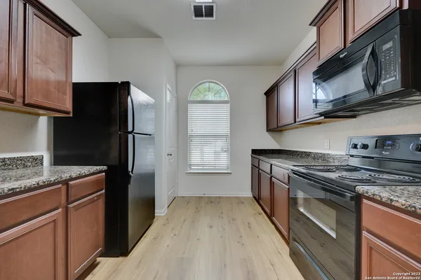 a kitchen with stainless steel appliances granite countertop a refrigerator stove and microwave