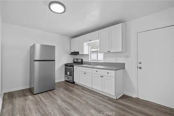 a kitchen with a refrigerator sink and cabinets