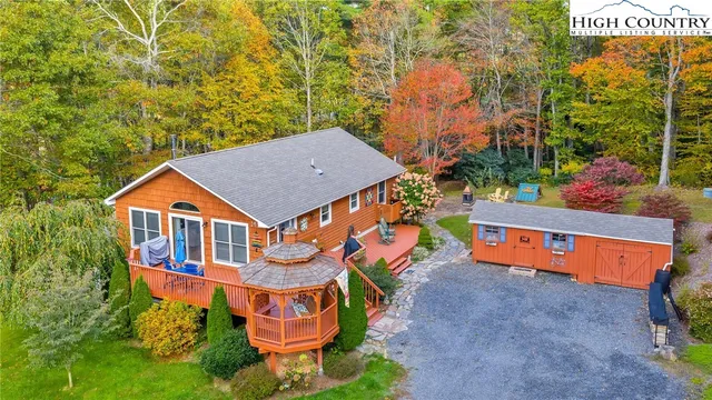 an aerial view of a house with swimming pool and large trees