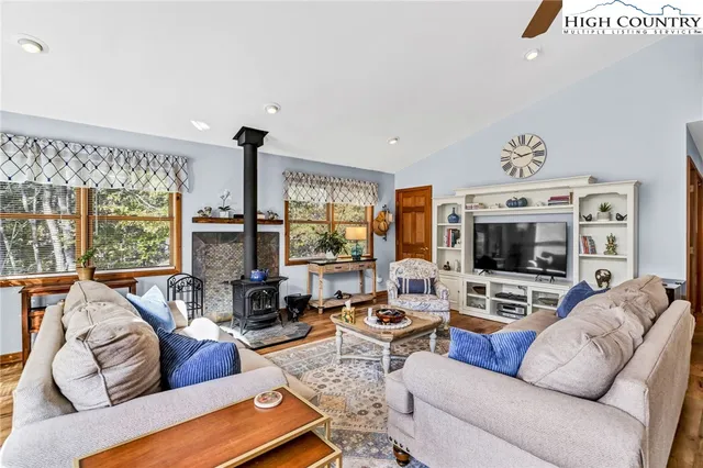 a living room with furniture flat screen tv and a large window
