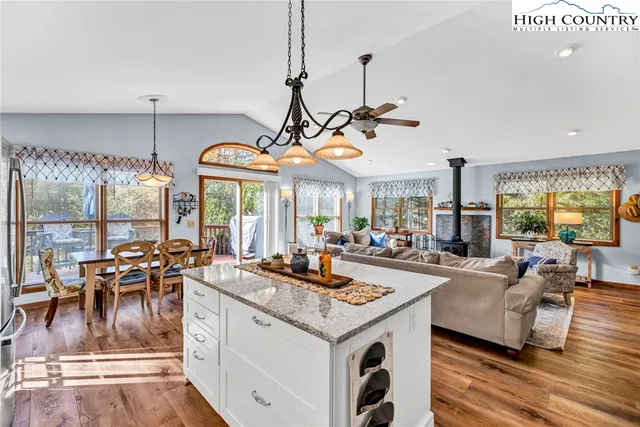 a view of a dining room and livingroom with furniture wooden floor a chandelier
