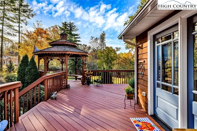 a balcony with wooden floor table and chairs