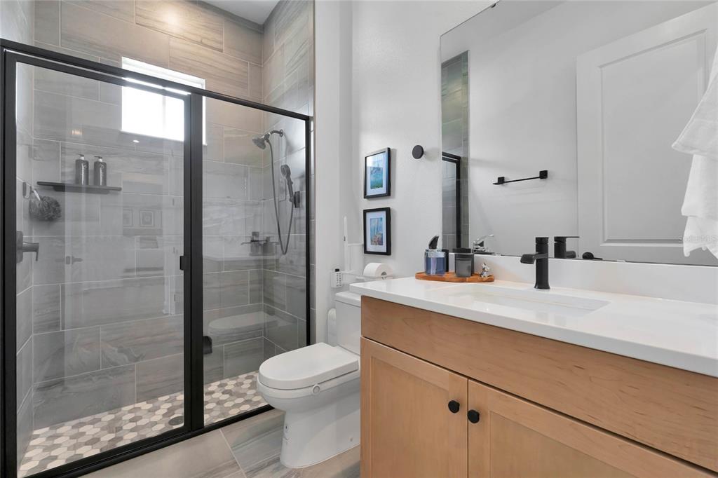 7540 Estuary Lake Loop Celebration, FL 34747 - Photo 19 of 35 a bathroom with a shower sink vanity mirror and toilet