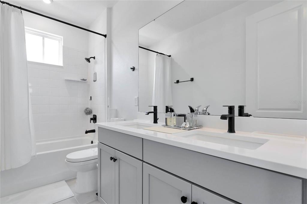 7540 Estuary Lake Loop Celebration, FL 34747 - Photo 22 of 35 a bathroom with a granite countertop sink a toilet and shower