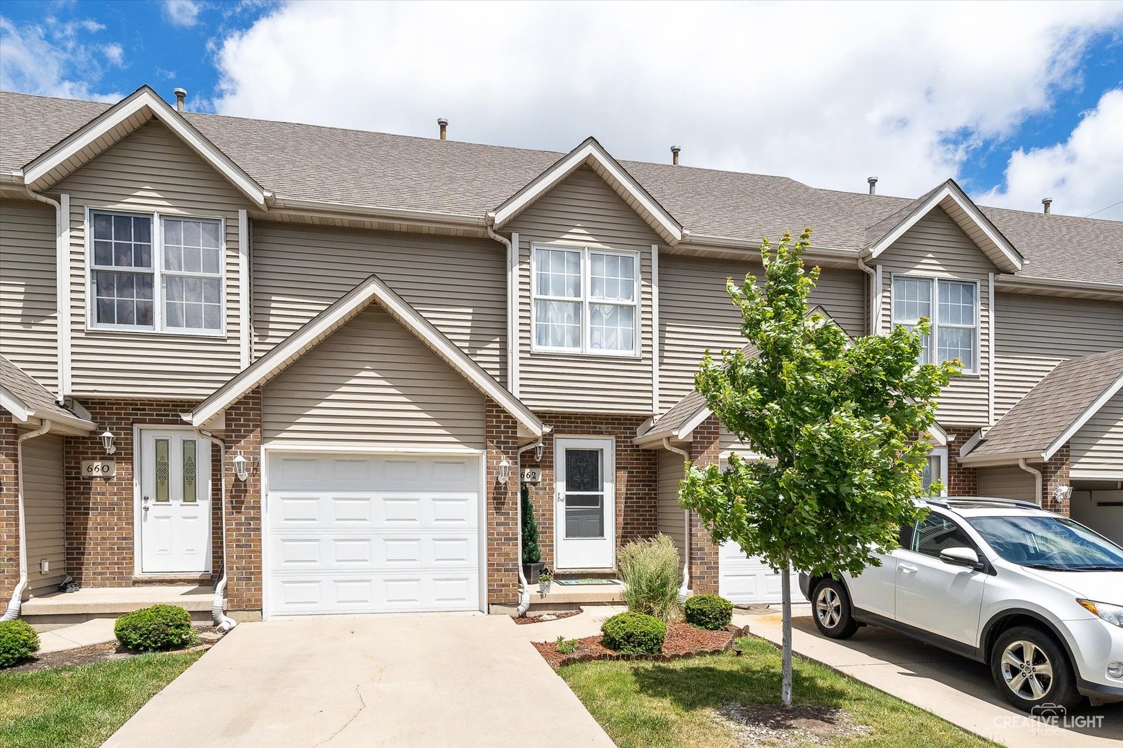 a front view of a house with a yard and garage