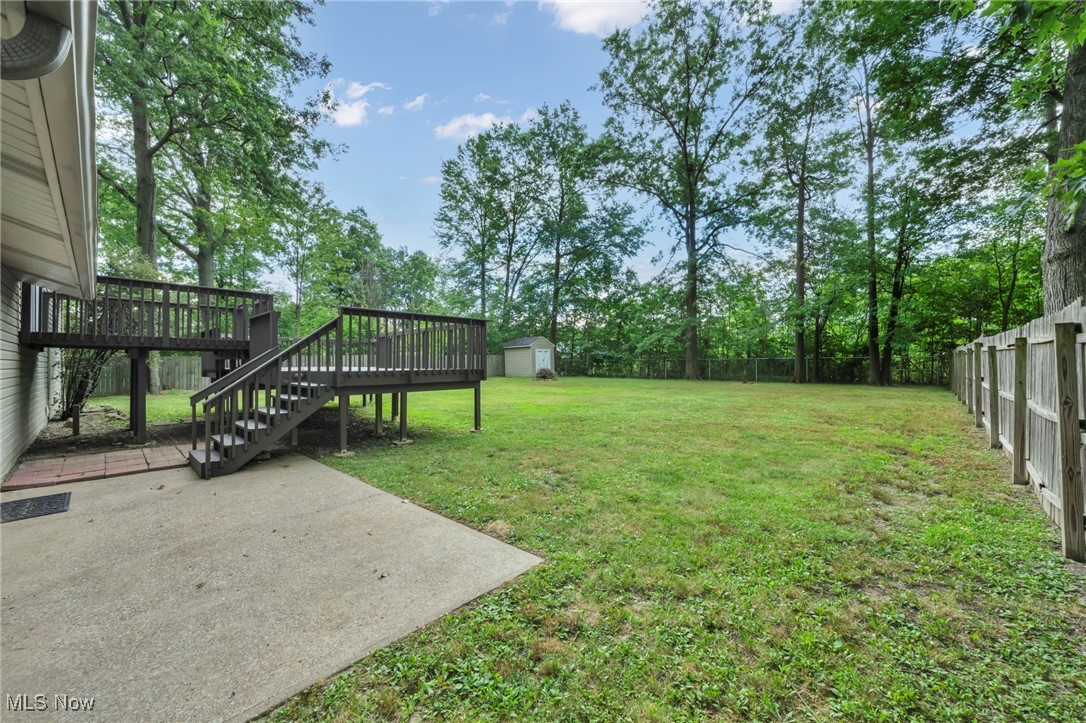 47655 Cooper Foster Park Road Amherst, OH 44001 - Photo 41 of 49 Fenced backyard with stairway, a patio area, a storage shed, and a wooden deck
