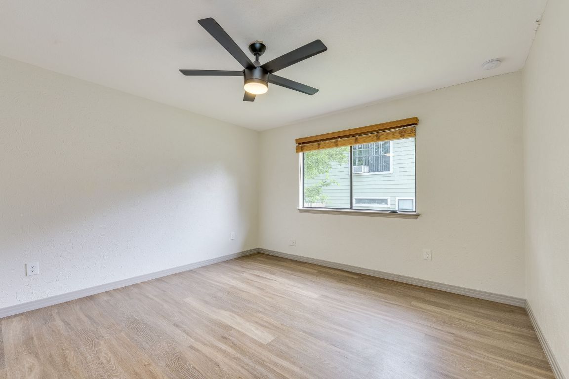 1416 Atterbury Lane Austin, TX 78754 - Photo 15 of 24 an empty room with wooden floor ceiling fan and windows