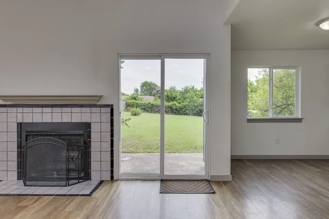 a living room with a fireplace and a floor to ceiling window