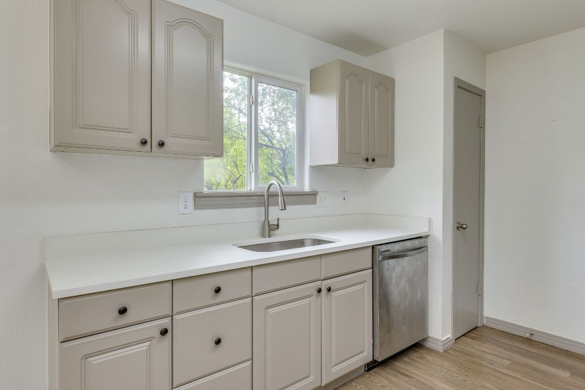 1416 Atterbury Lane Austin, TX 78754 - Photo 10 of 24 a kitchen with white cabinets and a sink